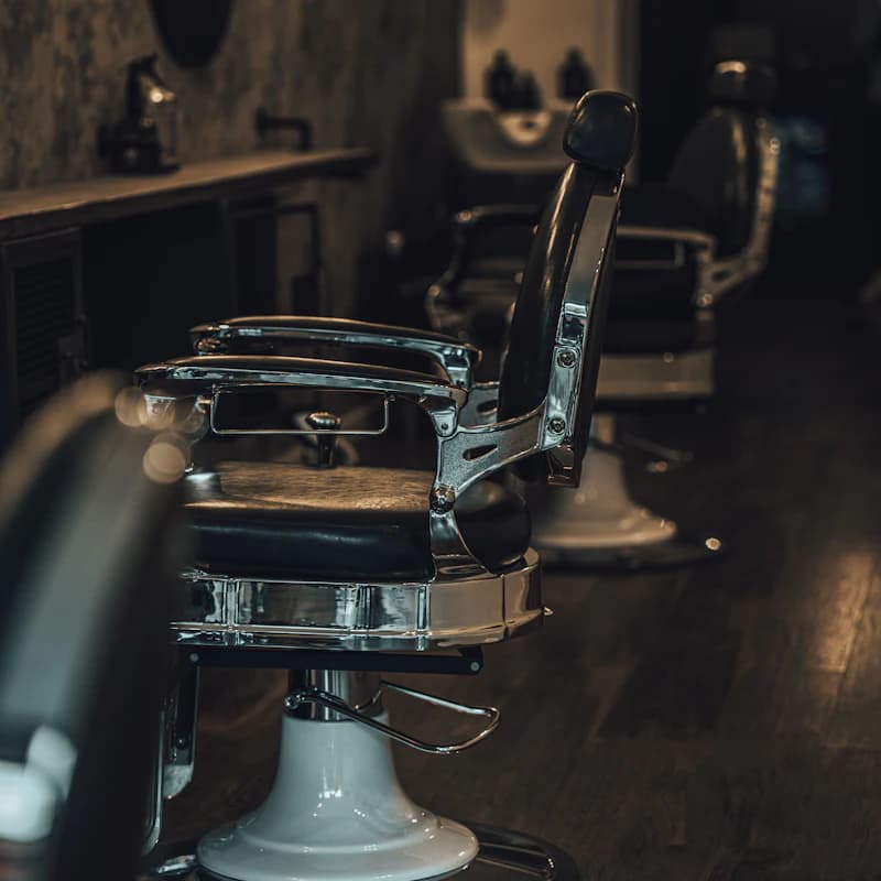 Sillón de barbería negro y plateado en barbería profesional
