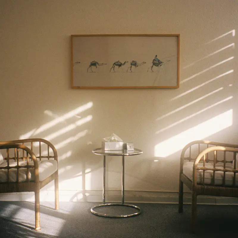 Consultorio de psicología con dos sillas y mesa bañados en luz natural